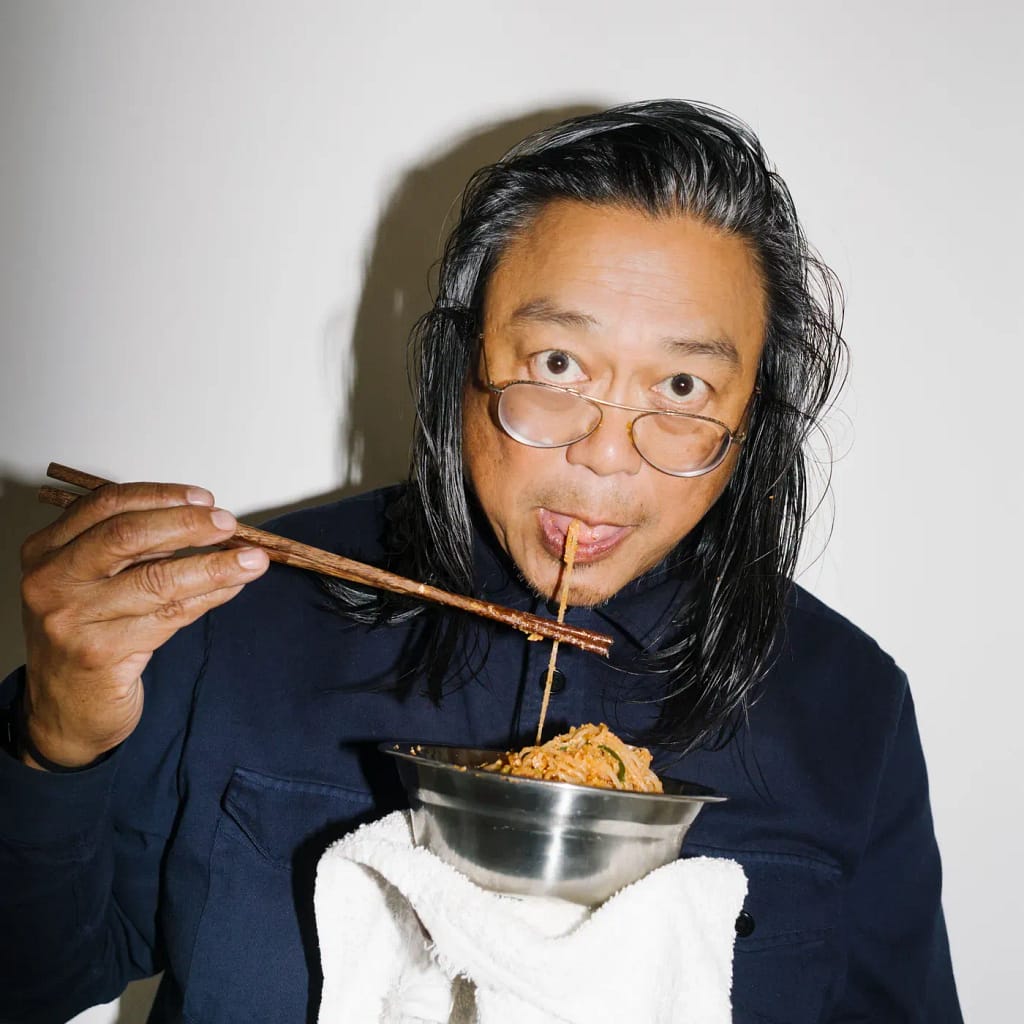 Art Basel Awards 2026 — Rirkrit Tiravanija s miskou jedla a paličkami, portrét 2023. Photo: Ryan Lowry.