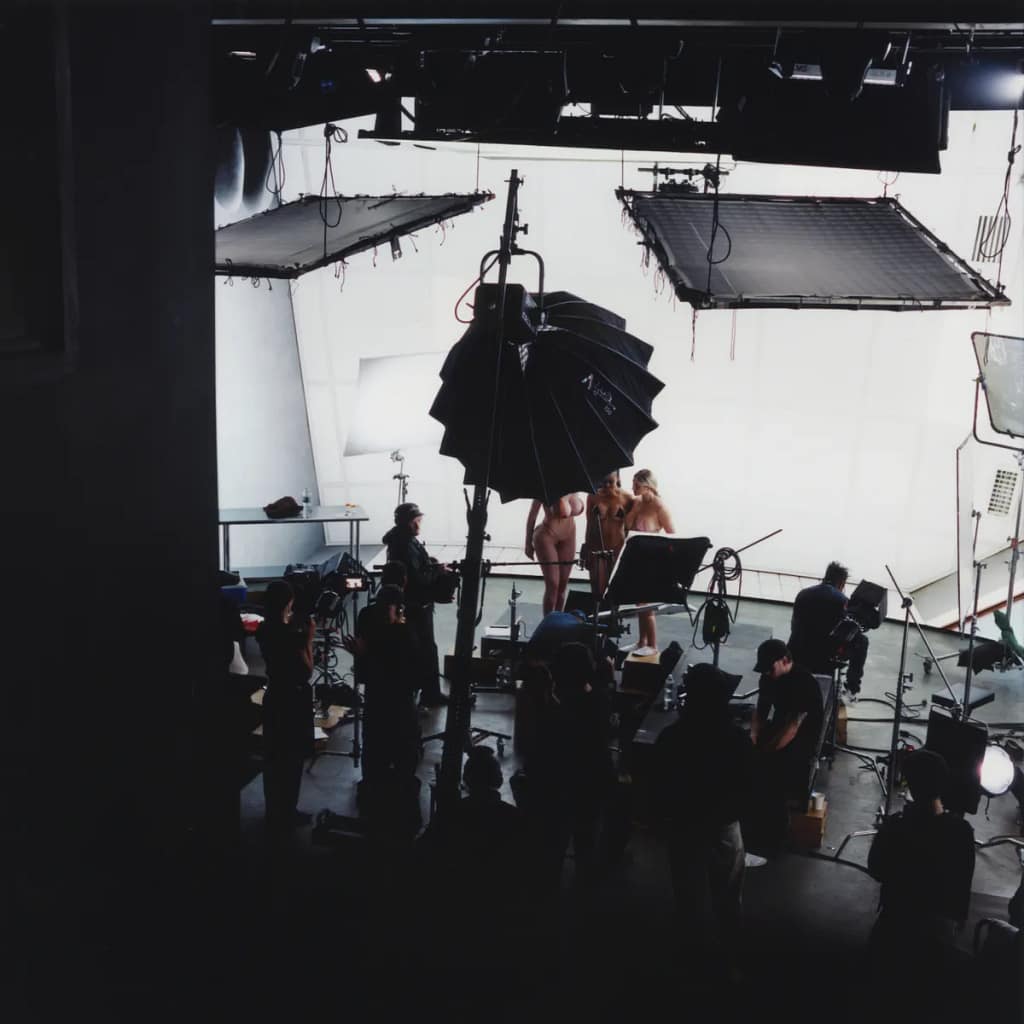 Záber zo zákulisia natáčania videodiel Maiy Malou Lyse Things to Come — filmové štúdio s osvetľovacou technikou a nahými herečkami v pozadí, 2026.