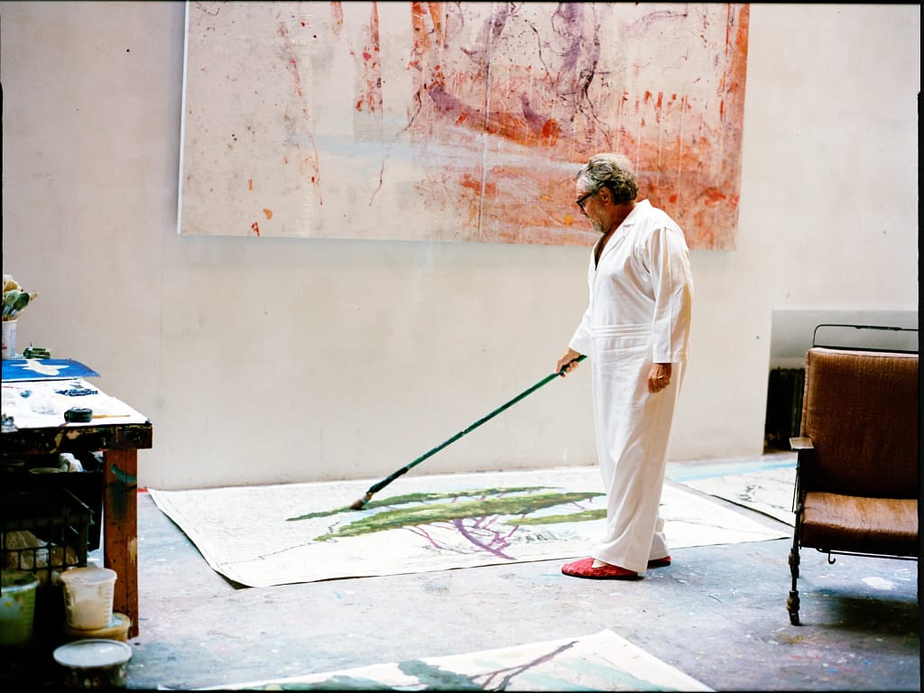 Julian Schnabel maľuje na podlahe ateliéru dlhým štetcom, séria Italy Through Its Trees, 2025. Foto: Sean Thomas. Zdroj: Sotheby's.
