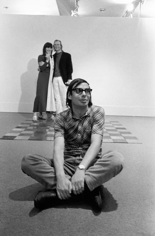 Galerista Konrad Fischer sedí pred dielom Carla Andreho, v pozadí Rune Mields a Sigmar Polke, Kunstmarkt Köln 1969