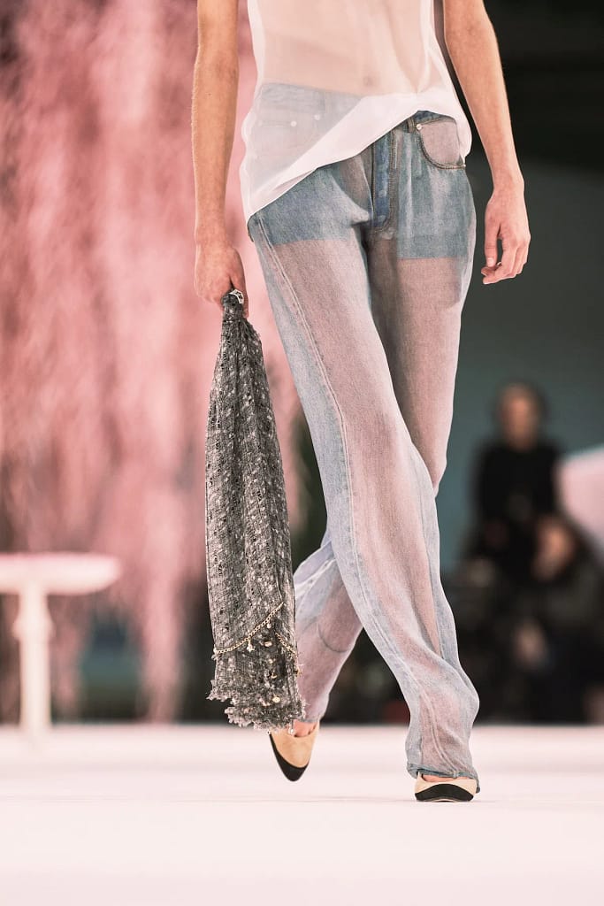 Fotografia z prehliadky Chanel SS 2026 v Paríži, kde Matthieu Blazy debutoval ako kreatívny riaditeľ. Modelky prezentujú tweedové kostýmy, pastelové scenérie a surrealistické prvky inšpirované literatúrou a popkultúrou.