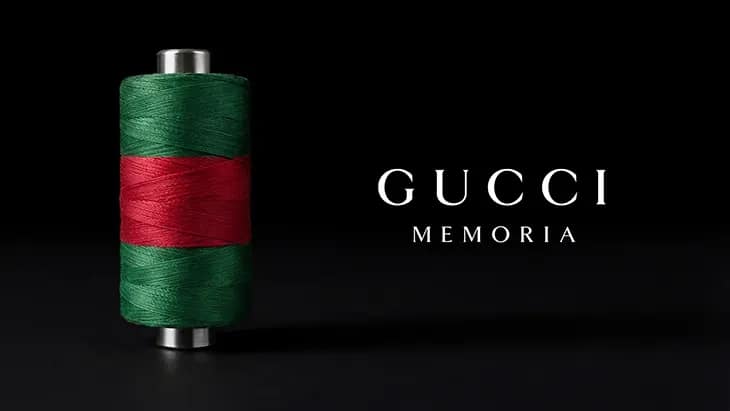 Vizuál výstavy Gucci Memoria — cievka so zelenou a červenou niťou na čiernom pozadí s nápisom Gucci Memoria.