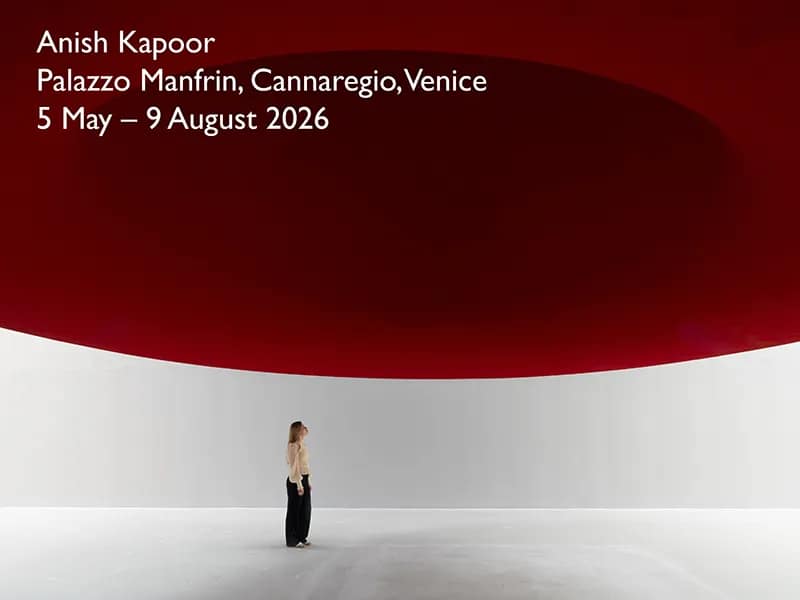 Anish Kapoor, inštalácia v Palazzo Manfrin, Cannaregio, Benátky – Venice Biennale 2026. Postava stojí pod masívnou tmavočervenou konkávnou skulptúrou v bielom priestore.