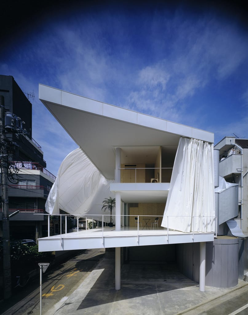 Curtain Wall House v Tokiu s posuvnými textilnými závesmi prepájajúcimi interiér a exteriér.